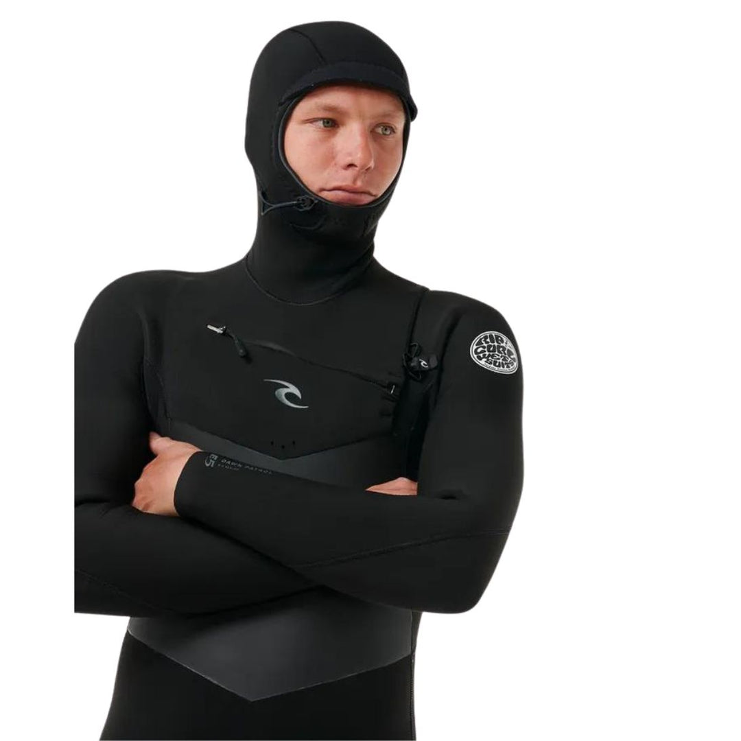 A male model wearing a Rip Curl Dawn Patrol 5/4mm black mens hooded wetsuit with a chest zip feature and yulex rubber. Close up view of the upper body and hood 