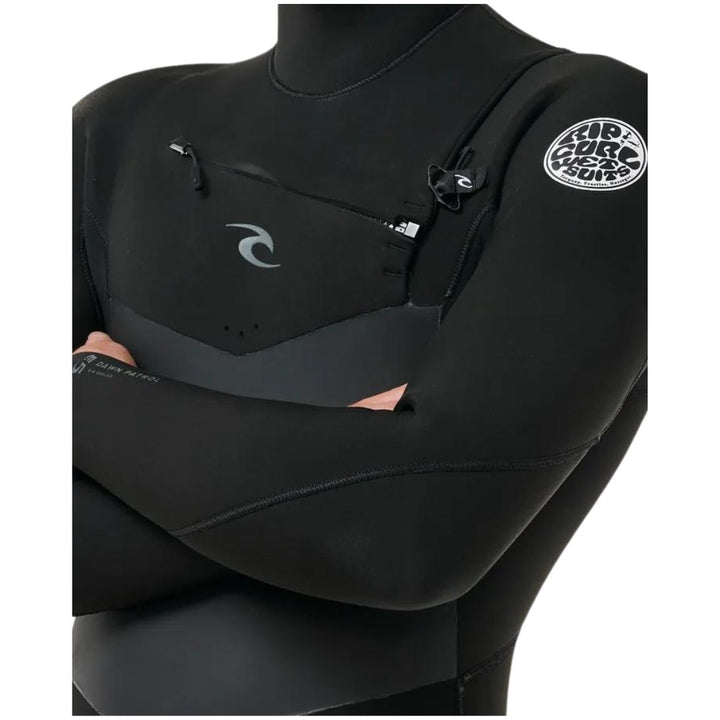 A male model wearing a Rip Curl Dawn Patrol 5/4mm black mens hooded wetsuit with a chest zip feature and yulex rubber. Close up view of the chest zip entry 