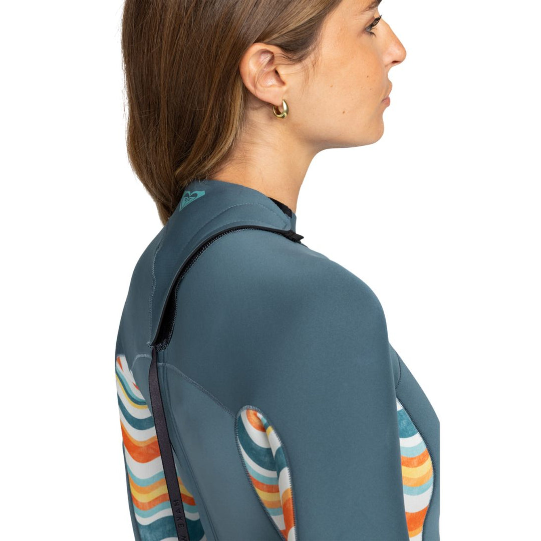 Studio photo of model wearing Roxy Swell Series Womens Shorty Wetsuit with long sleeves. Side close up view. 