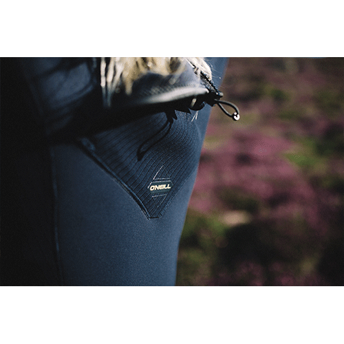 Blonde model close up of the O Neill logo on a Hyperfreak 5/4+ mm navy womens wetsuit 