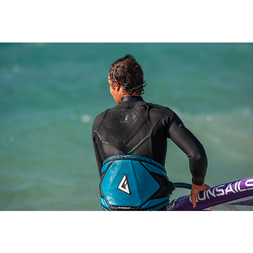 Model wearing 2020 O'Neill Mens Mutant Legend 5/4 Chest Zip Wetsuit with the  hood detached holding a sunsails windsurf sail